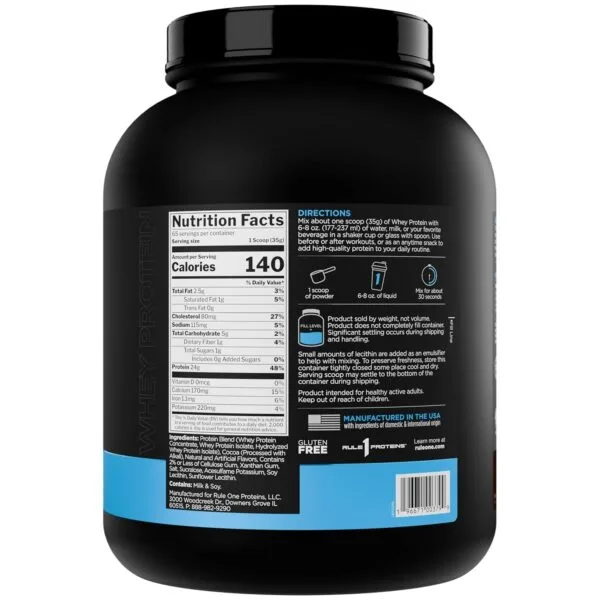 A black container of whey protein powder with a prominent label displaying nutrition facts, directions, and ingredients is visible against a white background.