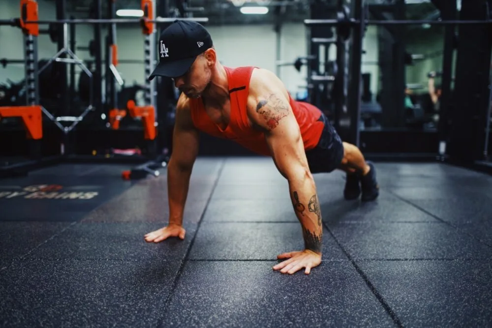 To do a Push-up you are going to get on the floor on all fours, positioning your hands slightly wider than your shoulders width. Extend your legs back so you are balanced on your hands and toes, your feet hip-width apart. Once in this position, here is how you will start to do a Push-up-