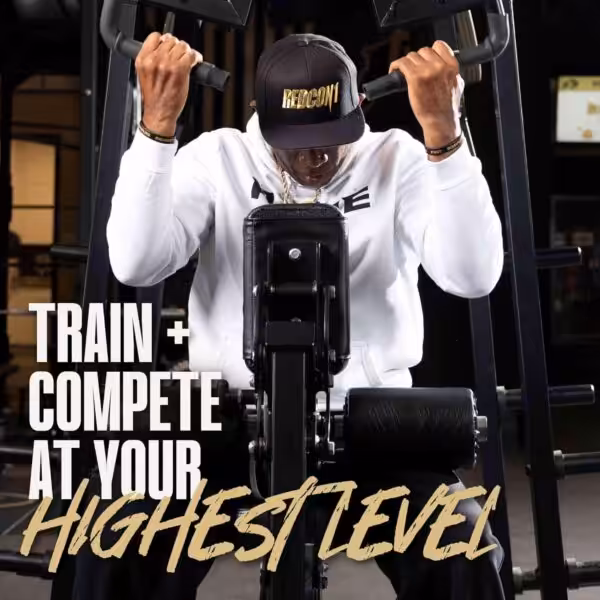 Train + Compete at Your Highest Level. A man works out on a gym machine