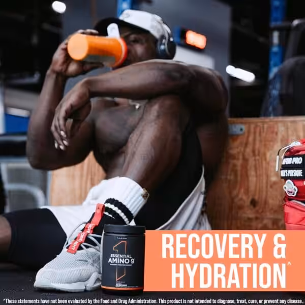Athlete resting in a gym drinking from a shaker bottle next to a container of Rule One Essential Amino 9 — Recovery & Hydration supplement