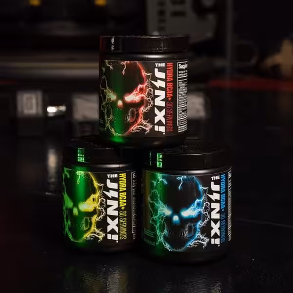 Three tubs of The Jinx Hydra BCAA+ supplement, 30 servings each, in red, yellow, and blue skull label variants