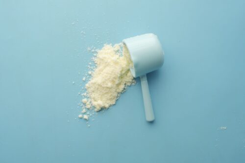 Scoop of EAA amino acid powder on a blue background