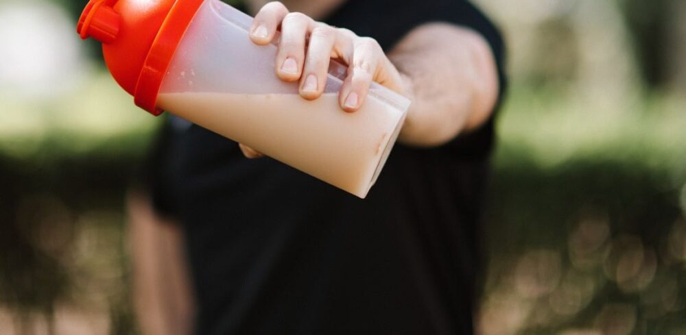 Shaker bottle with protein powder mixed in water, showing water with protein