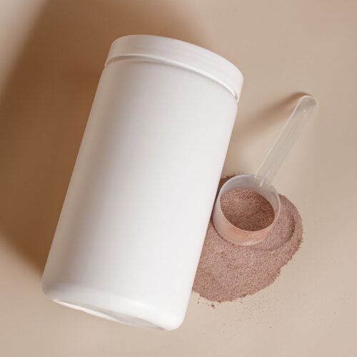 Unlabelled whey protein tub with a scoop of chocolate powder, comparing whey protein price and value